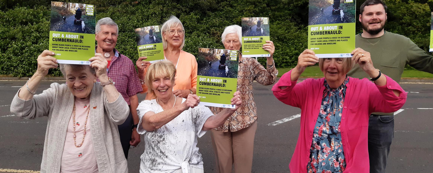 7 older people holding up reports and smiling